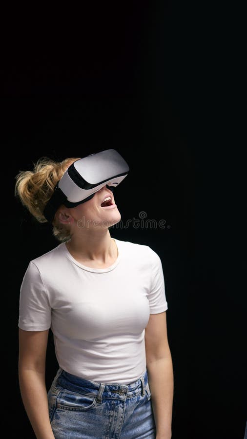 Femme découverte port casque de réalité virtuelle sur fond studio noir photographie stock
