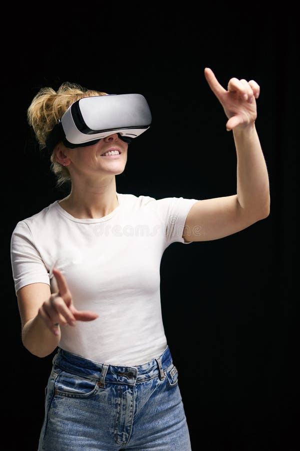 Femme découverte port casque de réalité virtuelle sur fond studio noir photo stock
