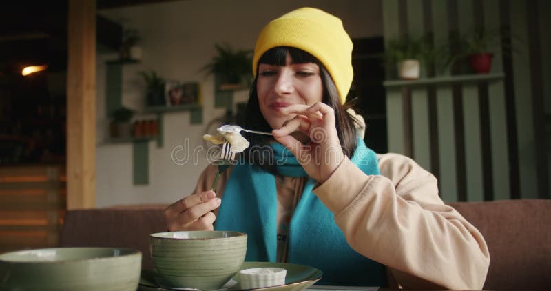 Femme dégustation de nourriture dans un restaurant savourant un plat crémeux. closeuse avec éclairage intérieur ambiant. gastronom banque de vidéos