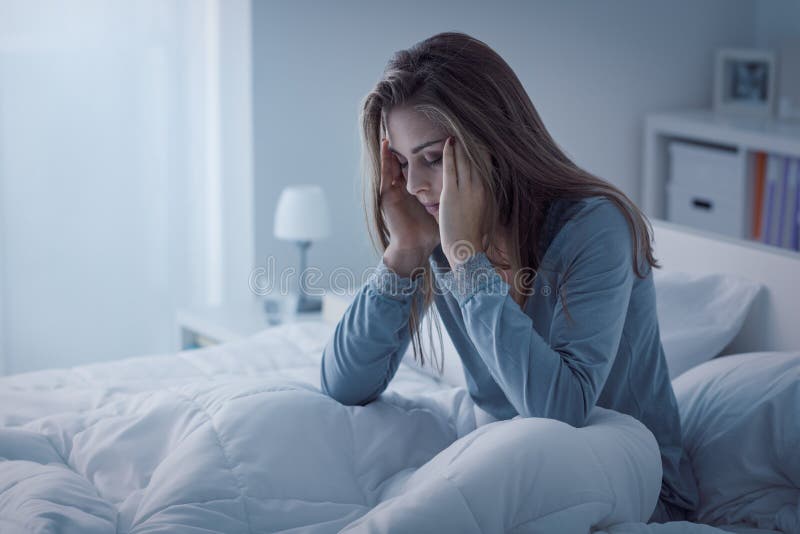 Femme déprimée éveillée pendant la nuit image stock Femme déprimée éveillée pendant la nuit image stock