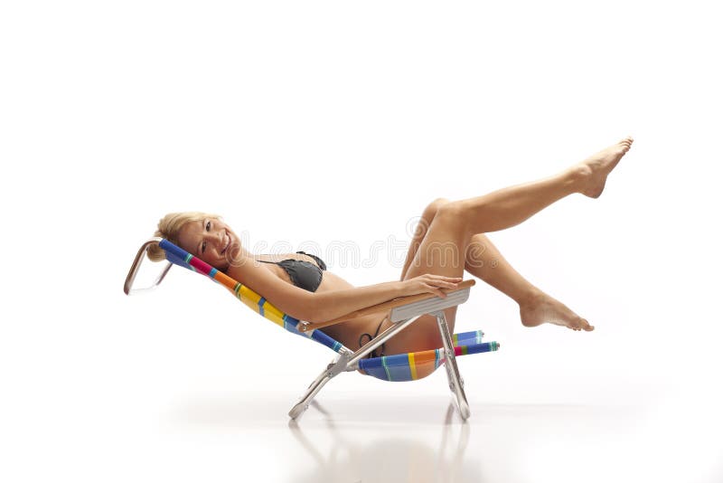 Femme détendant dans la présidence de plage photo stock Femme détendant dans la présidence de plage photo stock