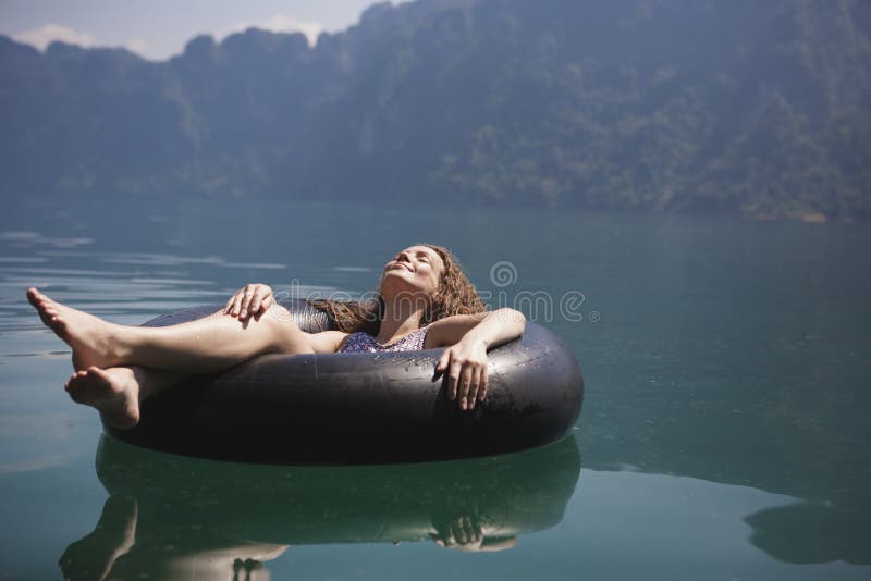Femme détendant sur un anneau de flottement image stock Femme détendant sur un anneau de flottement image stock