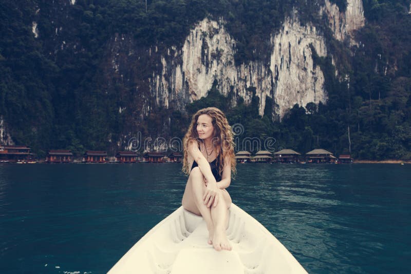 Femme détendant sur un canoë à un lac images libres de droits Femme détendant sur un canoë à un lac images libres de droits