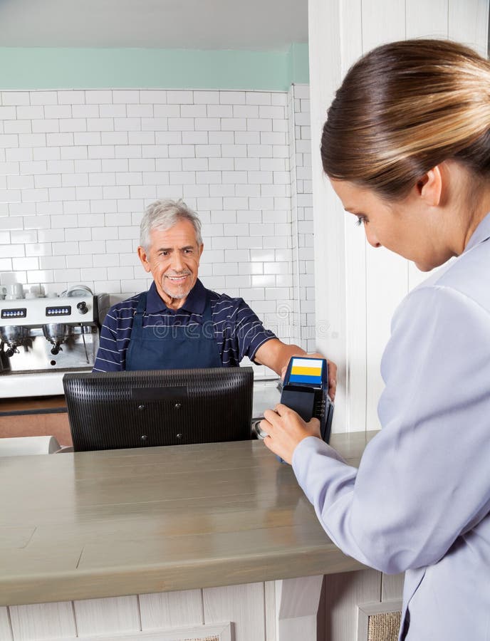 Femme effectuant le paiement par le portable à photo libre de droits Femme effectuant le paiement par le portable à photo libre de droits