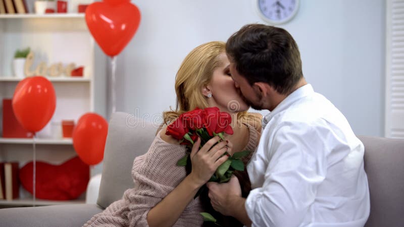 Femme embrassant l'homme, reconnaissant pour les fleurs, surprise romantique le jour de valentines photos stock Femme embrassant l'homme, reconnaissant pour les fleurs, surprise romantique le jour de valentines photos stock