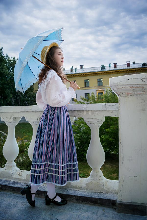 Femme en chemise vintage et une jupe longue avec un parapluie photo libre de droits