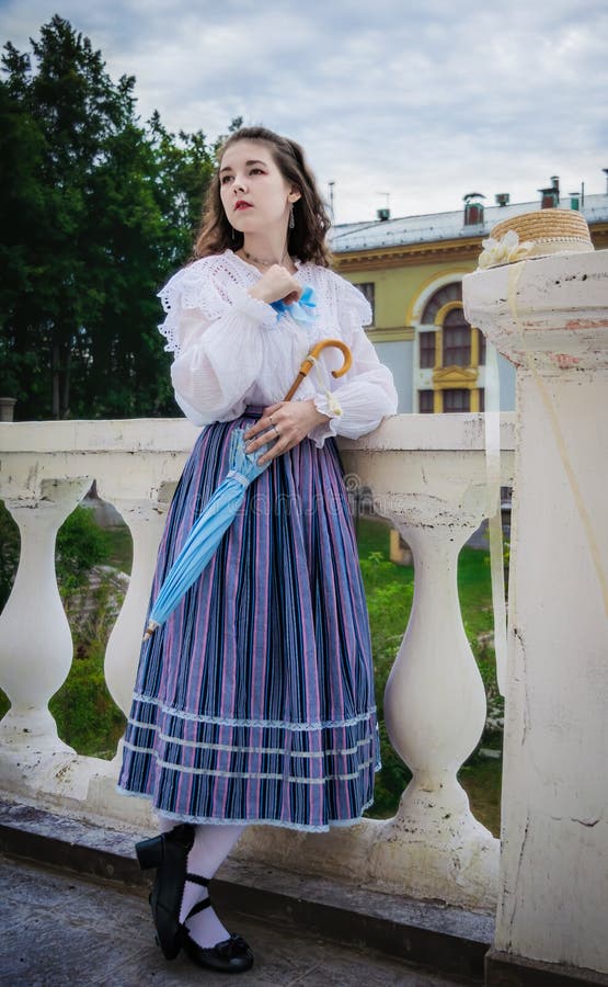 Femme en chemise vintage et une jupe longue avec un parapluie photos stock