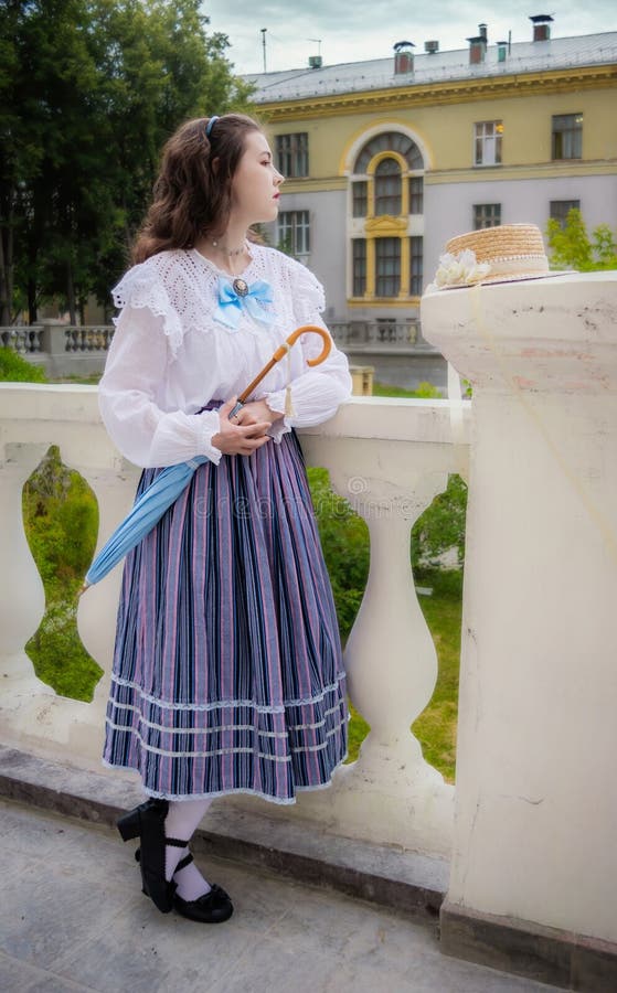 Femme en chemise vintage et une jupe longue avec un parapluie photo libre de droits