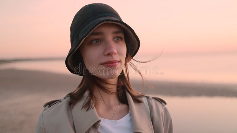 Femme en gros plan de capuchon sur le fond de la plage à l'automne. banque de vidéos