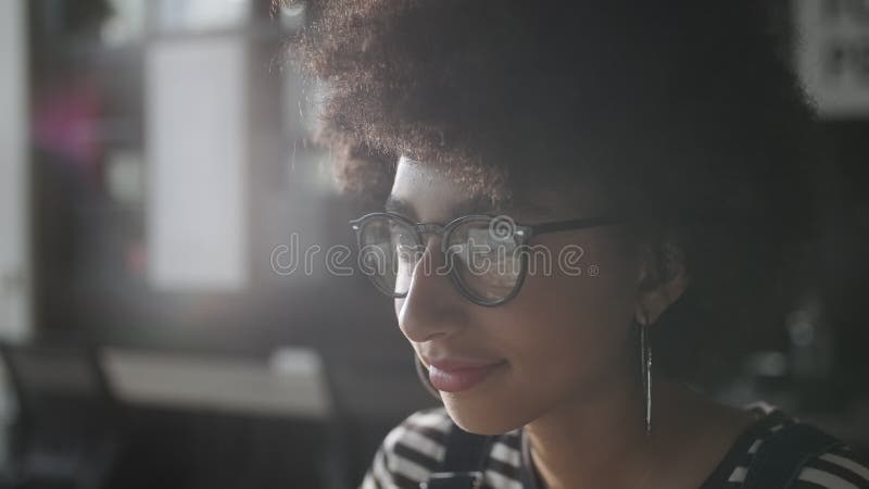 Femme en verres donnant sur le moniteur et surfer sur Internet. L'écran du moniteur se reflète dans les verres. Étroitement banque de vidéos
