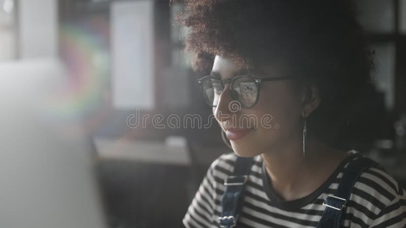 Femme en verres donnant sur le moniteur et surfer sur Internet. L'écran du moniteur se reflète dans les verres. Étroitement banque de vidéos