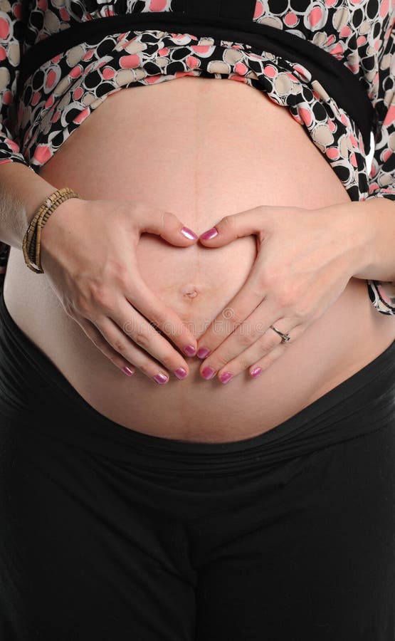 Femme enceinte avec des mains sur l'estomac photos stock Femme enceinte avec des mains sur l'estomac photos stock