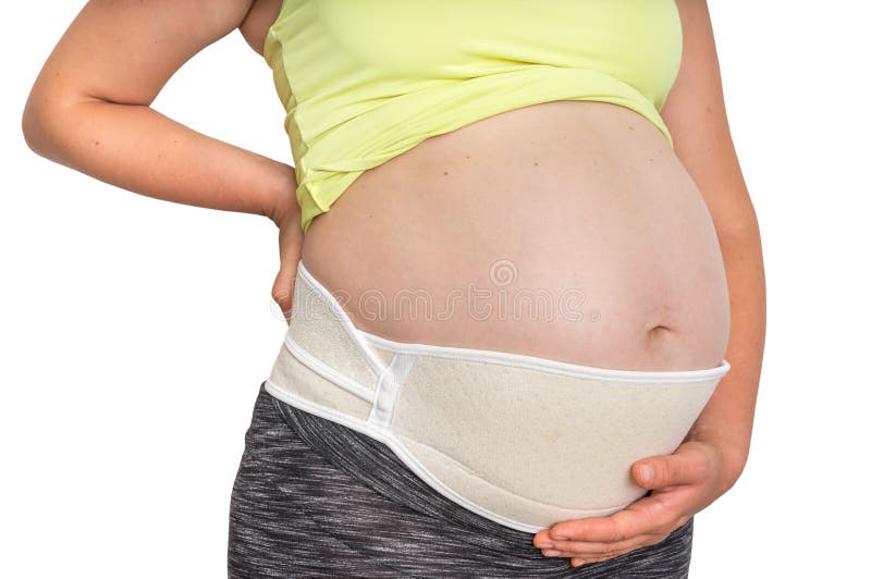 Femme enceinte avec la ceinture orthopédique de ventre d'isolement sur le blanc