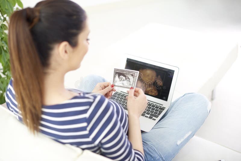 Femme enceinte avec la photo de l'ultrason 3D de son bébé image libre de droits Femme enceinte avec la photo de l'ultrason 3D de son bébé image libre de droits