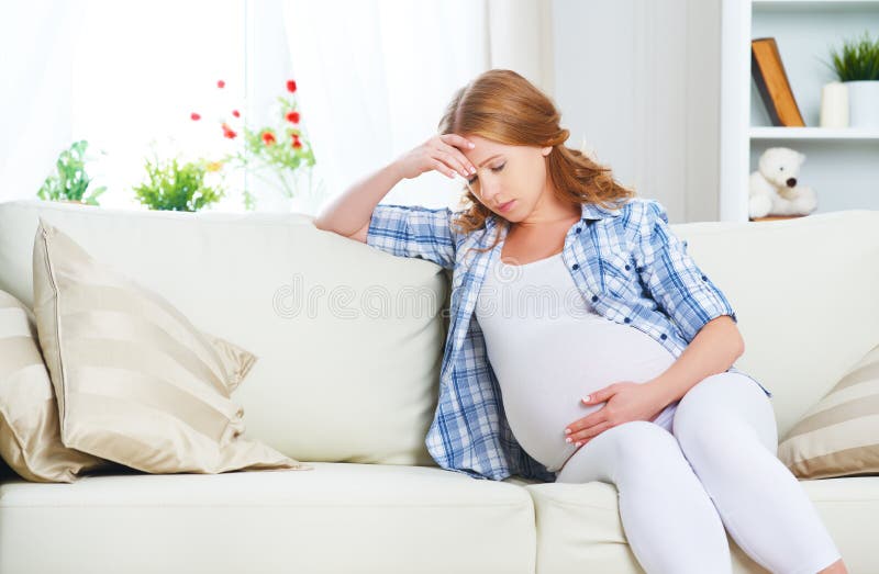 Femme enceinte avec le mal de tête et douleur
