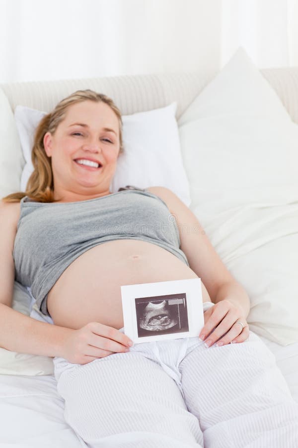 Jeune Femme Enceinte, Couché Dans Son Lit Avec Téléphone