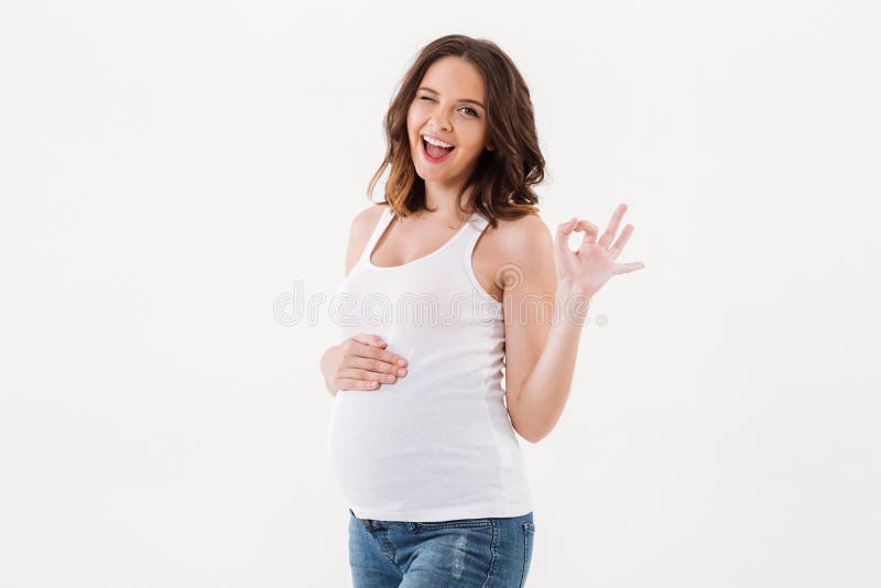Femme enceinte gaie montrant le geste correct