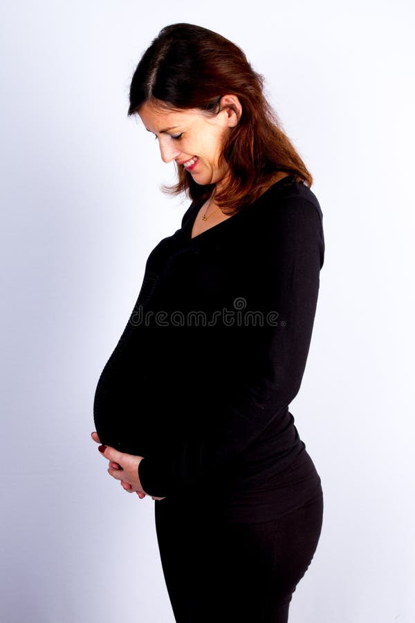 femme enceinte heureuse et fière regardant son ventre à l'arrière-plan gris blanc photo libre de droits femme enceinte heureuse et fière regardant son ventre à l'arrière-plan gris blanc photo libre de droits
