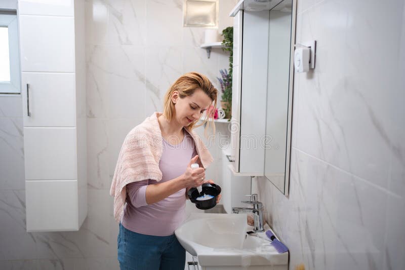 Femme enceinte préparant la teinture capillaire dans la salle de bain photos libres de droits