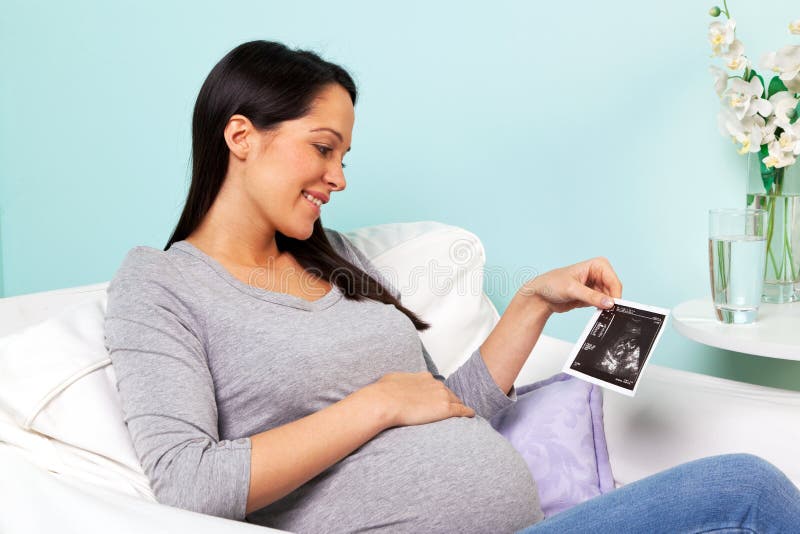 Femme enceinte regardant le balayage de chéri image libre de droits Femme enceinte regardant le balayage de chéri image libre de droits