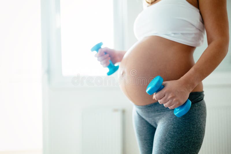 Femme enceinte sportive faisant des exercices à la maison images libres de droits Femme enceinte sportive faisant des exercices à la maison images libres de droits