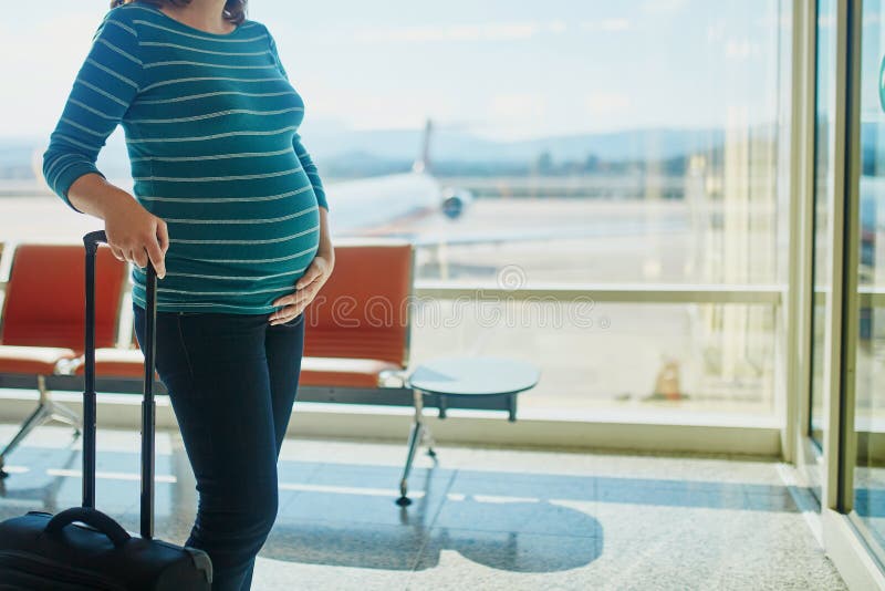 Femme enceinte voyageant en avion images libres de droits Femme enceinte voyageant en avion images libres de droits