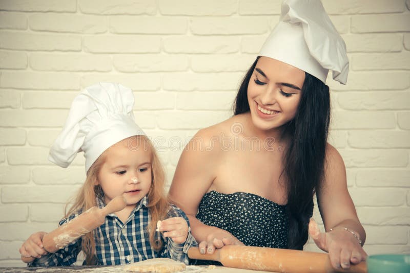 Femme et garçon dans des chapeaux de chef photographie stock libre de droits Femme et garçon dans des chapeaux de chef photographie stock libre de droits