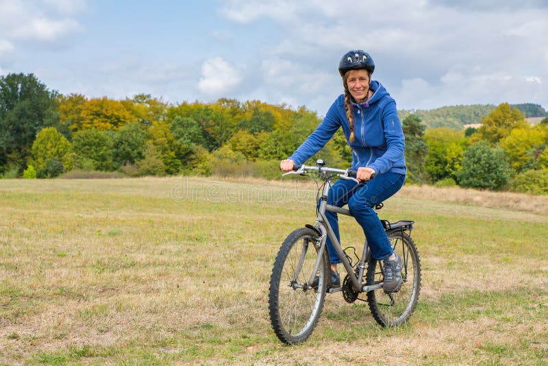 Femme européenne faisant un cycle sur le vélo de montagne en nature image libre de droits Femme européenne faisant un cycle sur le vélo de montagne en nature image libre de droits