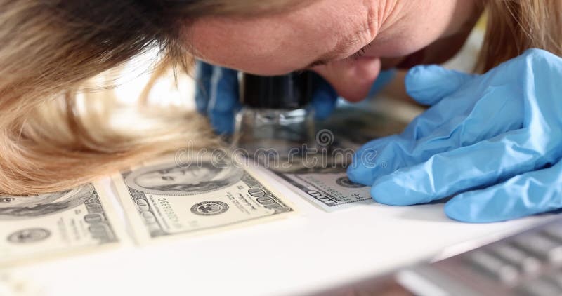 Femme examine les billets de dollars avec loupe et calculatrice banque de vidéos