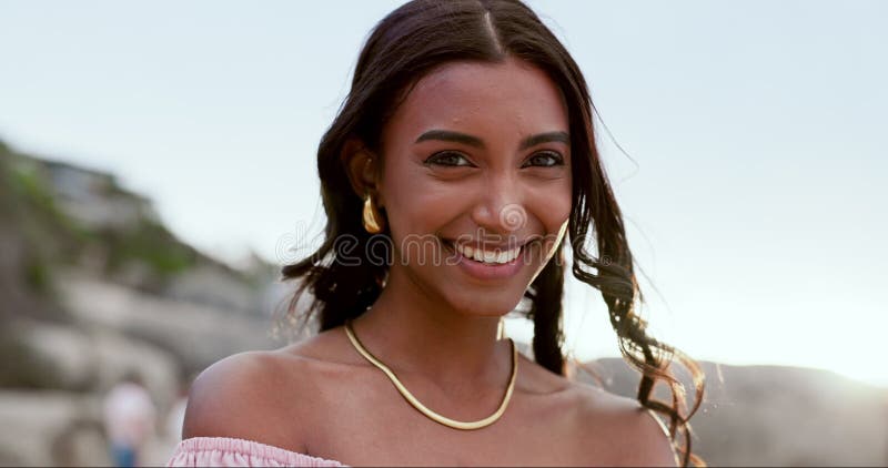 Femme face et vacances sur la plage souriant et heureux en plein air ou Voyage à l'océan pour le plaisir. femme indienne