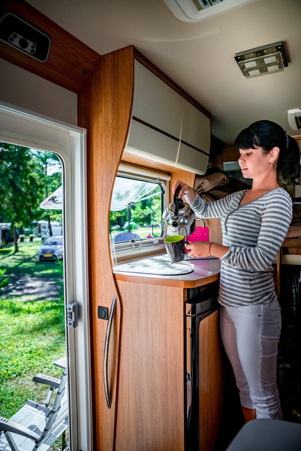 Femme faisant cuire dans le campeur, motorhome rv intérieur photo libre de droits Femme faisant cuire dans le campeur, motorhome rv intérieur photo libre de droits