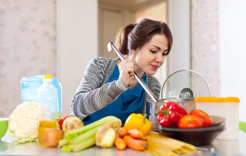 Femme faisant cuire le déjeuner de veggie avec le laddle images stock Femme faisant cuire le déjeuner de veggie avec le laddle images stock