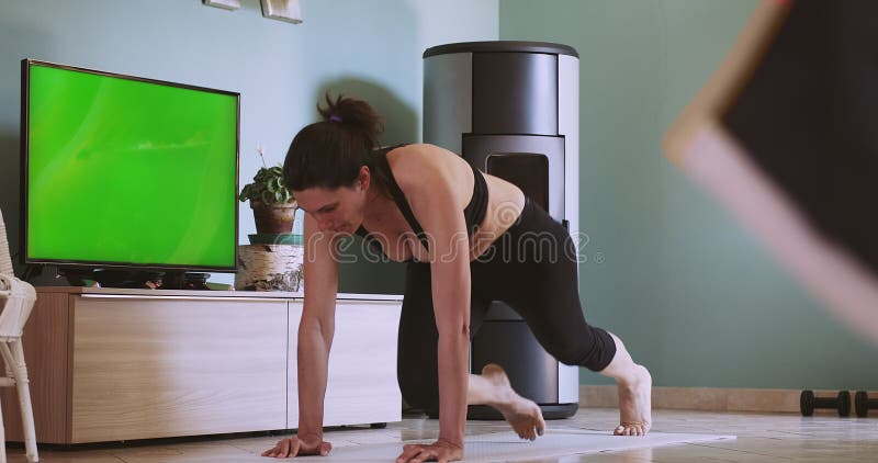 Femme faisant de l'exercice à la maison après un cours de remise en forme à distance. femme faisant l'entraînement à la maison ave banque de vidéos