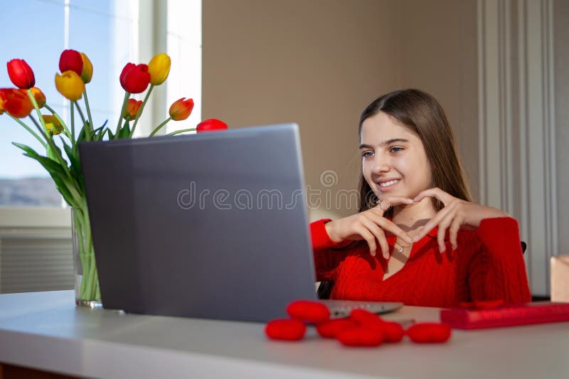 Femme faisant un geste cardiaque pendant un appel vidéo. Amour à distance. images libres de droits