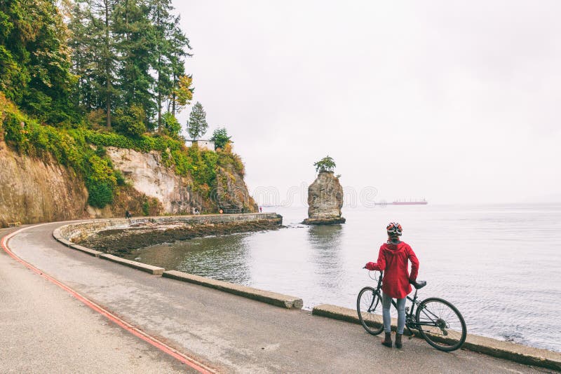 Femme faisante du vélo de cycliste de Vancouver sur le chemin de vélo autour de Stanley Park, activité de touristes célèbre en Co photos libres de droits Femme faisante du vélo de cycliste de Vancouver sur le chemin de vélo autour de Stanley Park, activité de touristes célèbre en Co photos libres de droits
