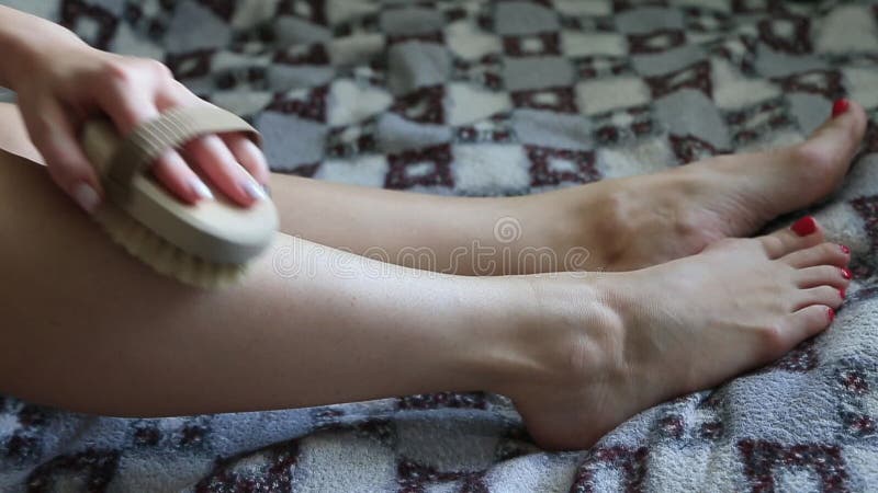 Femme fait massage des jambes avec pinceau de massage en bois doux pour le corps et les jambes closeuse banque de vidéos