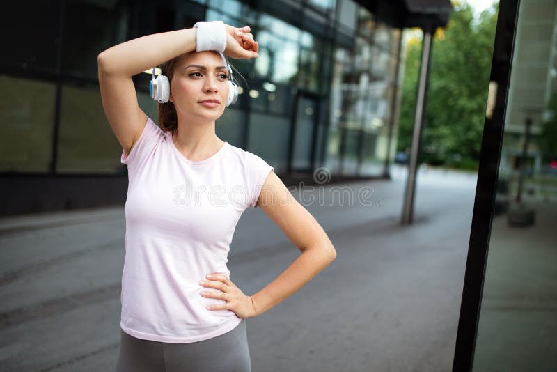 Femme fatiguée de coureur suant après fonctionnement extérieur photographie stock Femme fatiguée de coureur suant après fonctionnement extérieur photographie stock