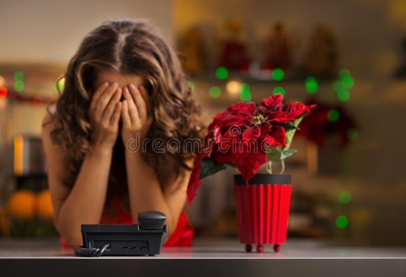 Femme frustrante attendant un appel téléphonique dans la cuisine de Noël photographie stock libre de droits Femme frustrante attendant un appel téléphonique dans la cuisine de Noël photographie stock libre de droits