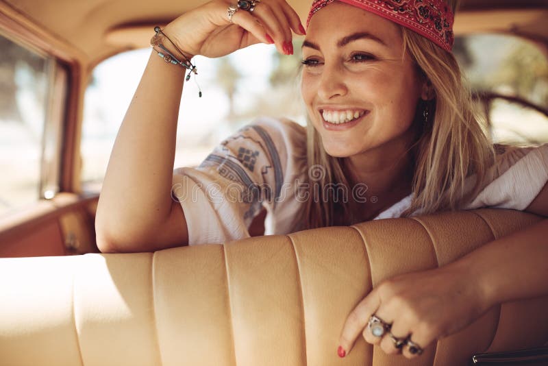 Femme gaie s'asseyant dans une voiture photos stock Femme gaie s'asseyant dans une voiture photos stock