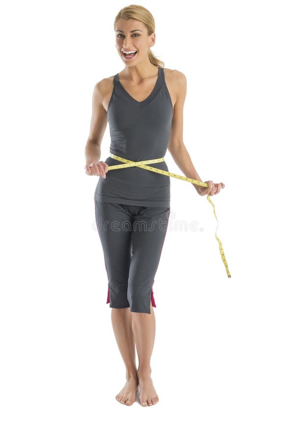 Femme gaie tenant le ruban métrique autour de la taille image stock Femme gaie tenant le ruban métrique autour de la taille image stock