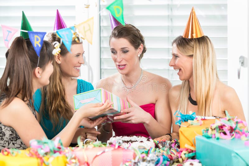 Femme gaie tenant un boîte-cadeau pendant une fête d'anniversaire de surprise images libres de droits Femme gaie tenant un boîte-cadeau pendant une fête d'anniversaire de surprise images libres de droits