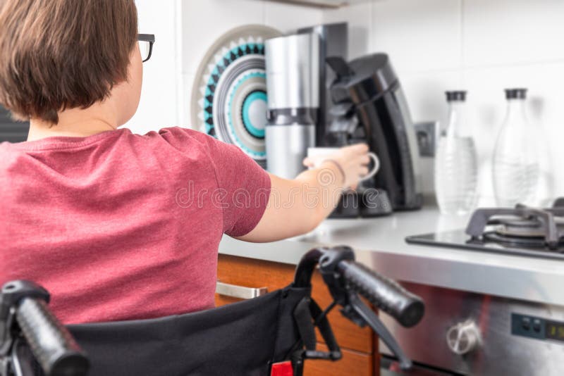 Femme handicapée obtenant le café dans la cuisine photos stock Femme handicapée obtenant le café dans la cuisine photos stock