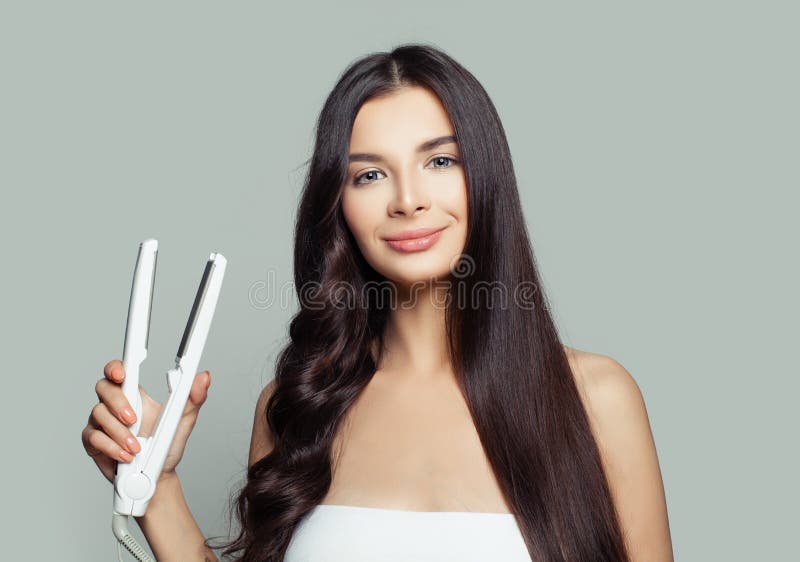 Femme heureuse avec les cheveux droits et les cheveux bouclés utilisant le redresseur de cheveux Coiffure saine de redressage de image stock Femme heureuse avec les cheveux droits et les cheveux bouclés utilisant le redresseur de cheveux Coiffure saine de redressage de image stock