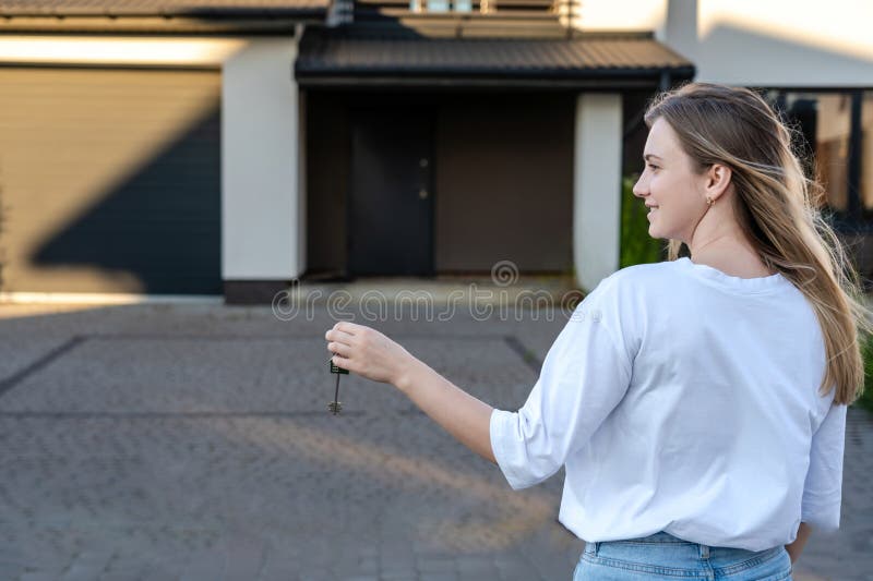 Femme heureuse avec les clés de la nouvelle maison arrière-plan. location immobilière pour réinstallation. assurance-location et a image libre de droits