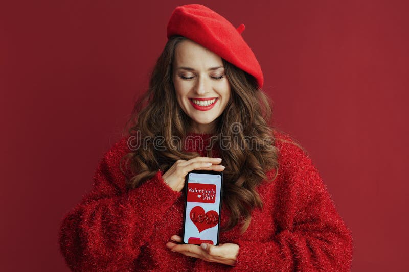 Femme heureuse avec un long smartphone à cheveux ondulés et Valentine app photo libre de droits