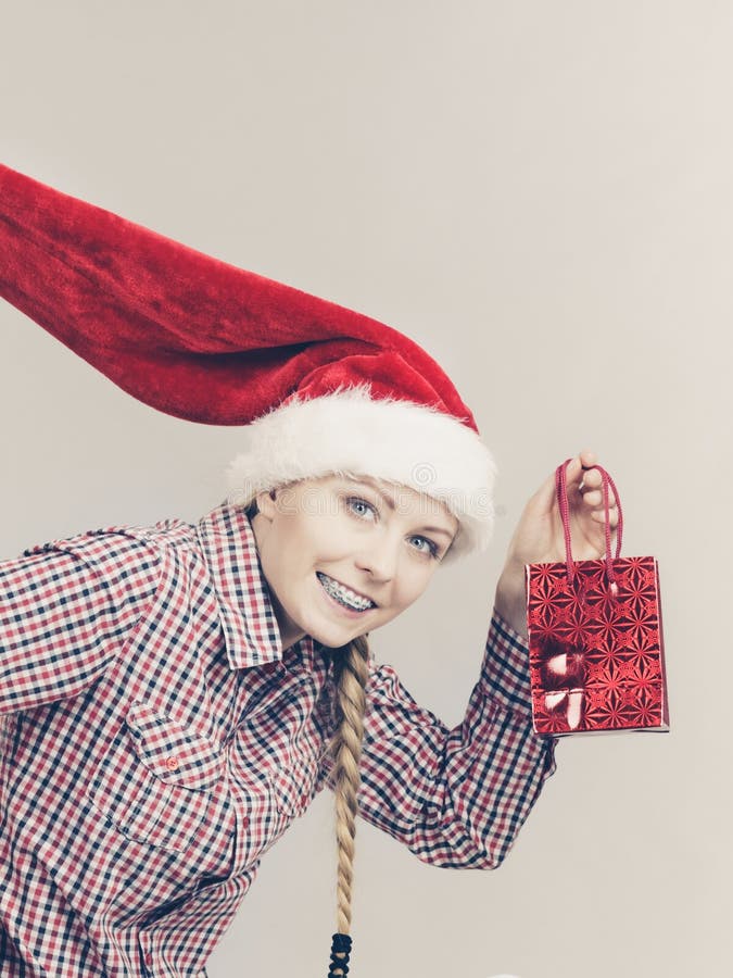 Femme heureuse d'achats utilisant le chapeau de Santa photo libre de droits Femme heureuse d'achats utilisant le chapeau de Santa photo libre de droits