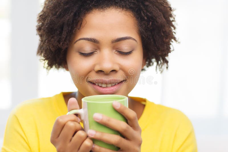 Femme heureuse d'afro-américain buvant de la tasse de thé photos libres de droits Femme heureuse d'afro-américain buvant de la tasse de thé photos libres de droits