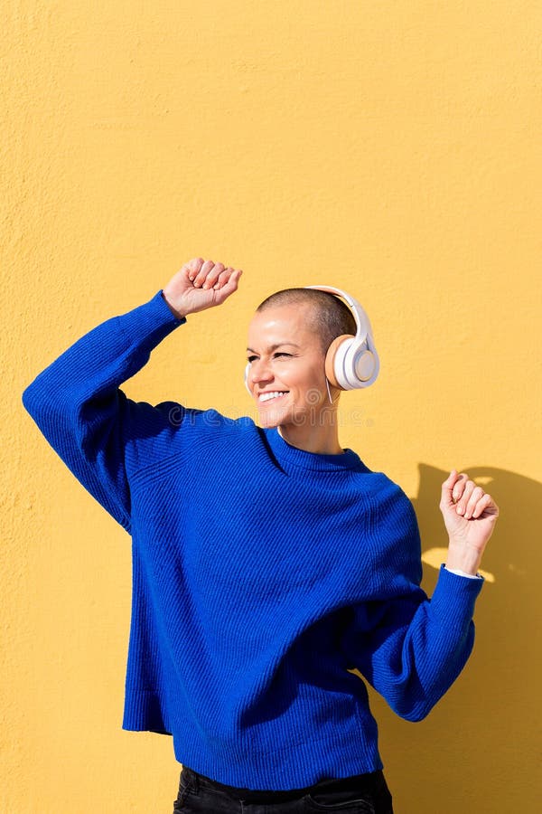 Femme heureuse dansant écoutant de la musique sur les écouteurs photo libre de droits
