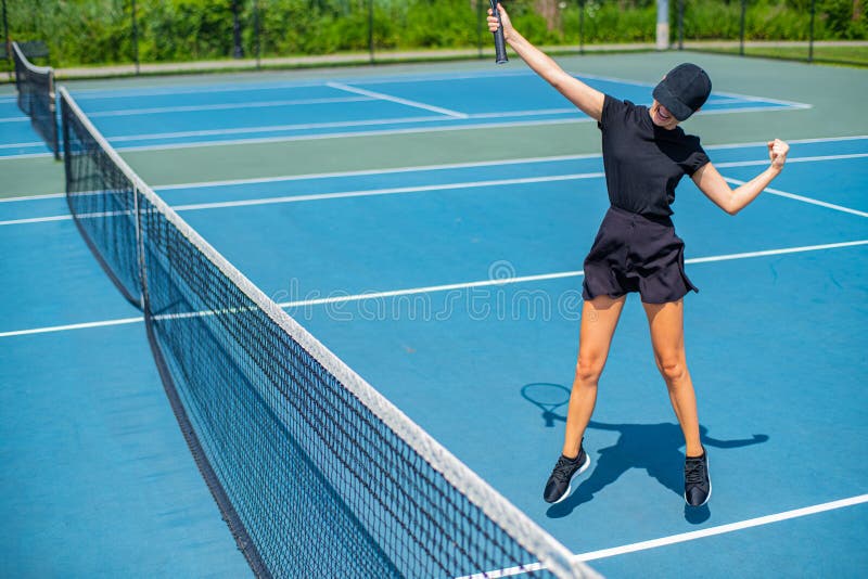 Femme heureuse de joueur de tennis célébrant la victoire dans la balle de match, le succès et la victoire image stock Femme heureuse de joueur de tennis célébrant la victoire dans la balle de match, le succès et la victoire image stock