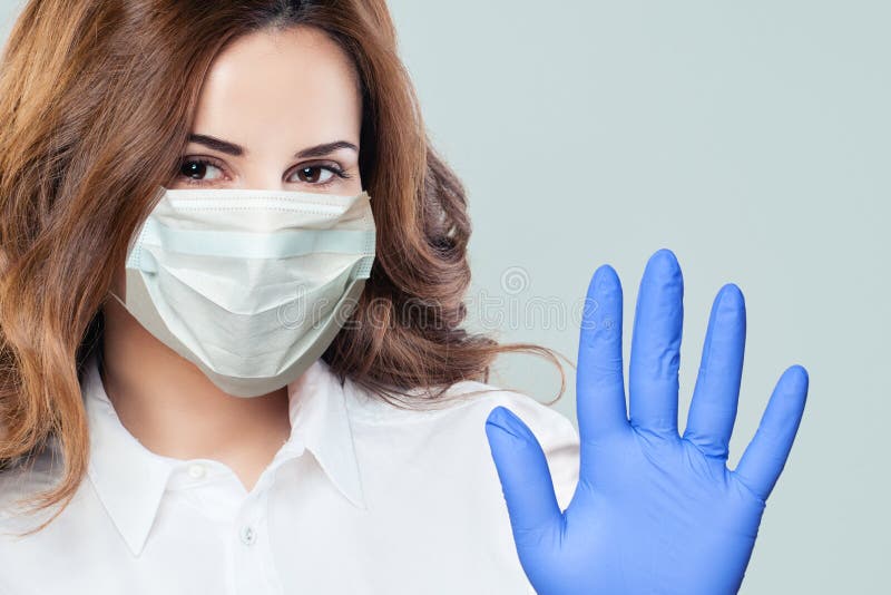 Happy doctor woman in medical face mask with stop gesture. Woman in safety mask and medical gloves. Virus protection, health and hygiene concept. Happy doctor woman in medical face mask with stop gesture. Woman in safety mask and medical gloves. Virus protection, health and hygiene concept
